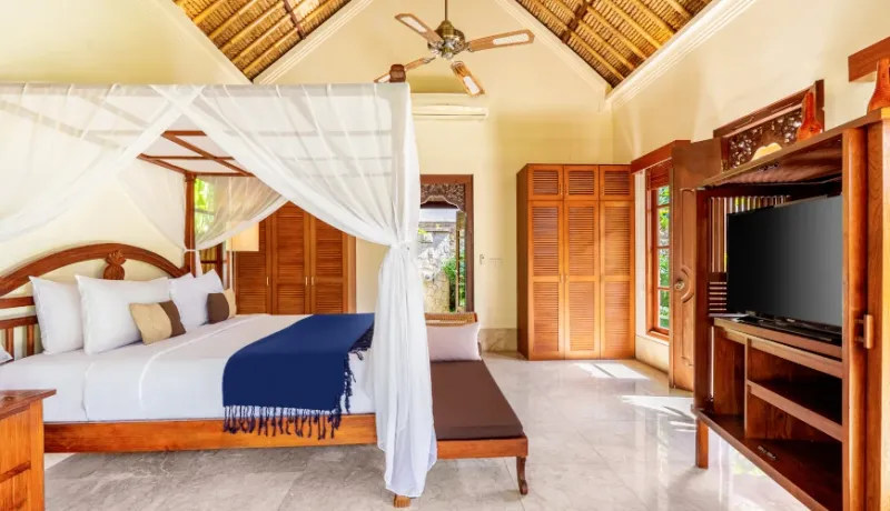 Spacious Balinese bedroom with a thatched roof at Villa Umarya