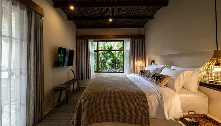 Spacious bedroom with a bed and light streaming from outside at Villa Xanadu