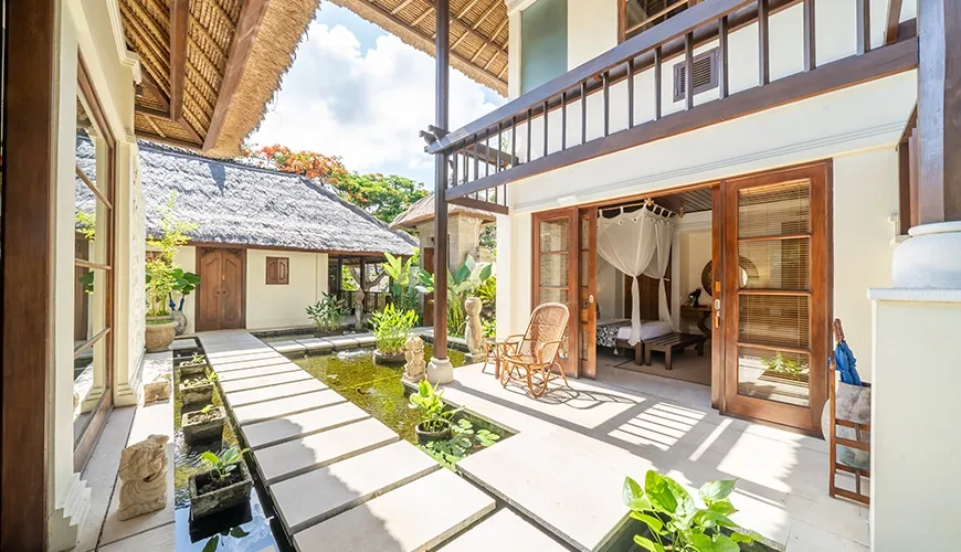 Lush garden with beautiful water feature and traditional villa buildings at Villa Yasmine