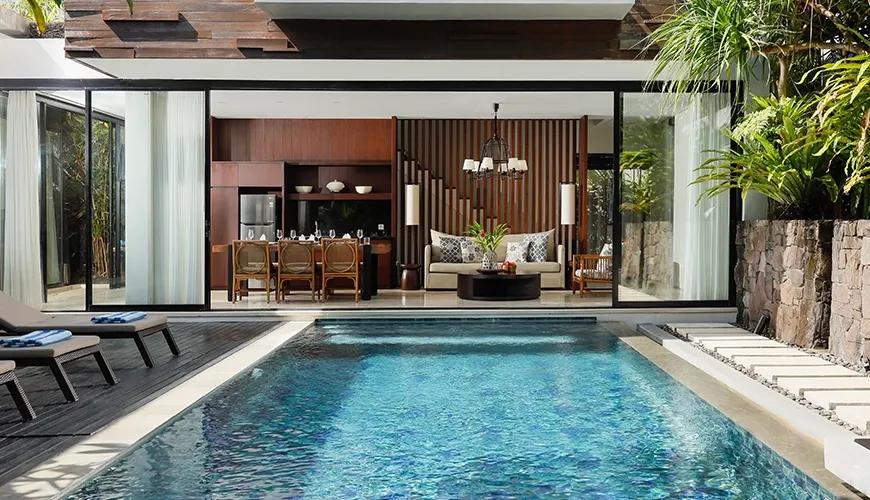 Luxury villa featuring an outdoor private swimming pool with views of the modern open living area at Vinila Villas Duplex