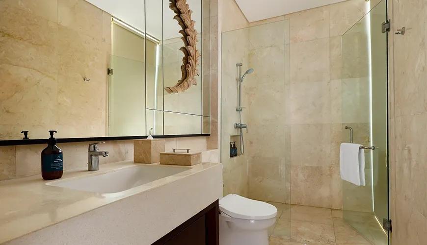 Modern luxury villa bathroom featuring a marble vanity and glass walk in shower at Vinila Villas Duplex
