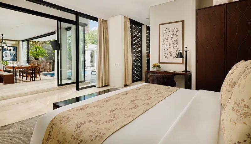 Modern villa bedroom featuring a large bed and sliding glass doors opening to the living area at Vinila Villas Duplex