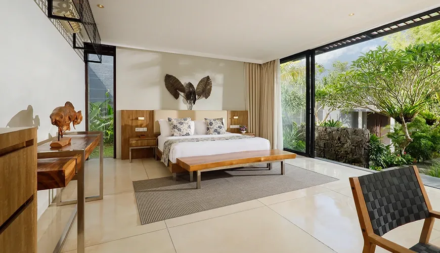 Modern bedroom with a desk and tropical garden view at vinila villas