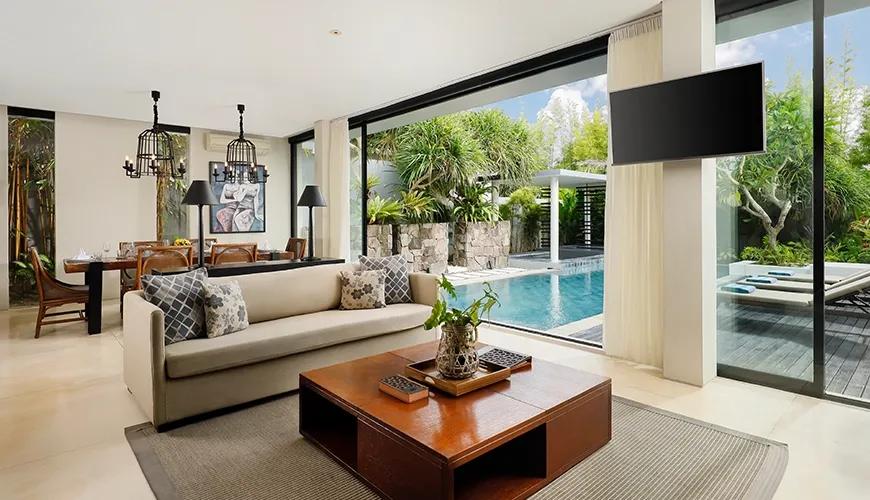 Spacious open plan living and dining area featuring glass doors with a view of the pool at Vinila Villas Suite
